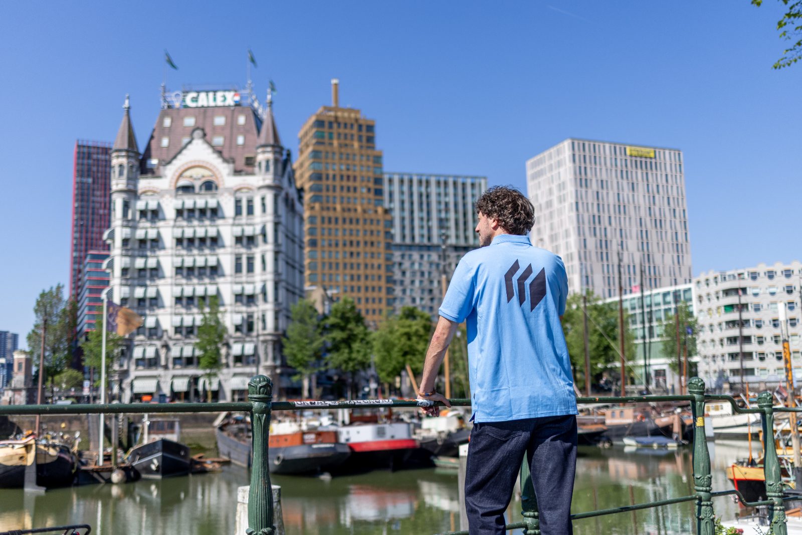 Micros-medewerker van achteren kijkt naar de skyline van de Oude Haven in Rotterdam.